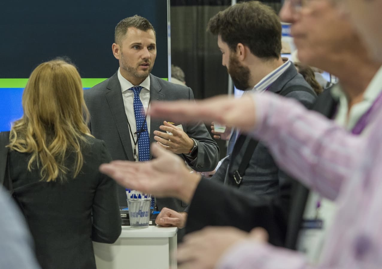 Exhibitor engaging with attendee at live event in exhibit hall